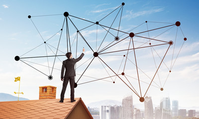 Businessman on house roof presenting networking and connection concept. Mixed media