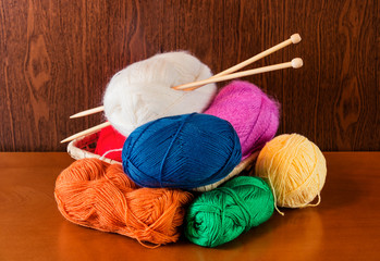 Balls of yarn in basket with knitting needles. Selective focus