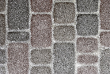 Paving stone covered with a thin layer of snow
