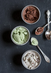 Range of coconut milk ice cream with chocolate, matcha powder, chocolate chips and vanilla. On a dark background, top view. Gluten free vegetarian dessert