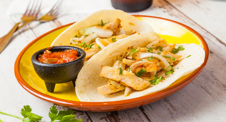 Mexican food: tacos with chicken and spicy sauce.