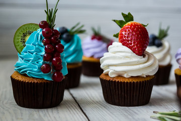 Chocolate cupcakes. Cupcakes. Cupcakes with berries,fruit,strawberries. Top view.colorful cupcake,tasty cake,colorful cream,cupcakes with summer berries on wooden background,close up,dessert concept