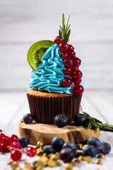 Chocolate cupcakes.Cupcakes with berries,fruit,strawberries. Top view.colorful cupcake,tasty cake,colorful cream,candies,cupcakes with summer berries on wooden background,close up,dessert concept