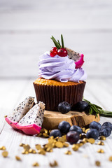 Chocolate cupcakes.Cupcakes with berries,fruit,strawberries. Top view.colorful cupcake,tasty cake,colorful cream,candies,cupcakes with summer berries on wooden background,close up,dessert concept