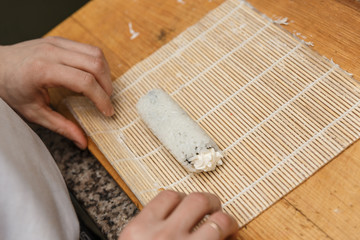 Preparing, rolling sushi.