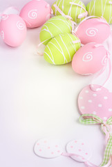 Easter pink and green painted eggs on white background and copy space.