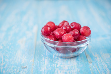 Frozen berries cherry on vintage wooden table.