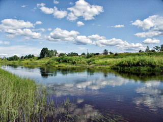 Fototapeta na wymiar Beautiful summer rural landscape with river and clouds on the blue sky.