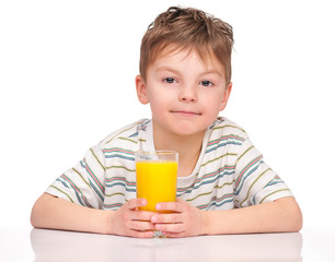 Portrait of happy little boy drinking refreshing orange juice. Smiling child with glass of fresh lemonade.