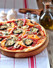 Homemade pizza with eggplant, ham, chorizo, mushrooms, onions and cheese.