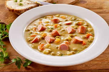 Bowl of Creamy Pea Soup with Chopped Sausage