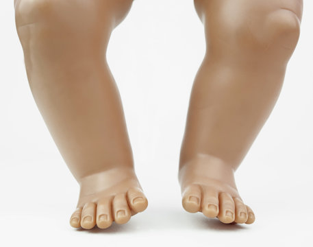 Isolated baby doll's feet, legs and knees.