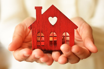 Warm and cozy miniature house in female hands. Care and love.