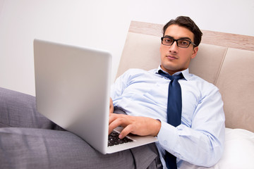 Businessman working in the bed at home