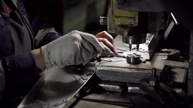 Machine and workers hands close-up in factory