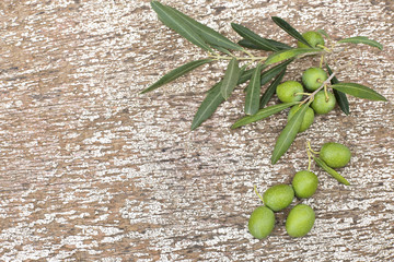Branch with olives, leaves on wooden 