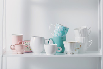 Clean dishes on white wooden shelf