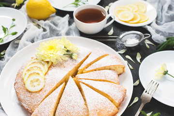 Lemon pie and cup of tea on decorated wooden table.