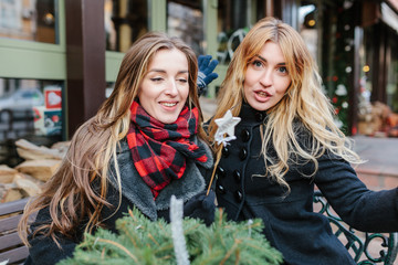 girls walk and perfectly spend time. They sit on a bench and have a good time. One of girls holds a...