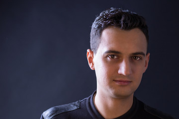 Obraz premium Close-up portrait of black-haired man on black background