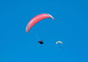 Two paragliders flying in the blue sky. Paragliding. 