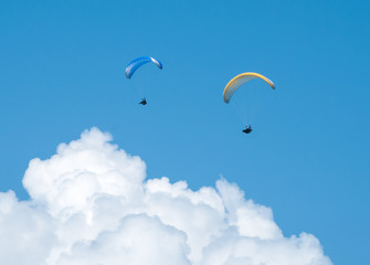 Two paragliders flying in the blue sky. Paragliding. 