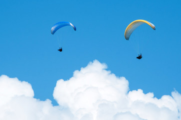 Two paragliders flying in the blue sky. Paragliding. 