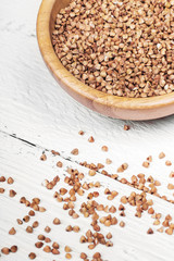buckwheat in bowl isolated on white wooden background