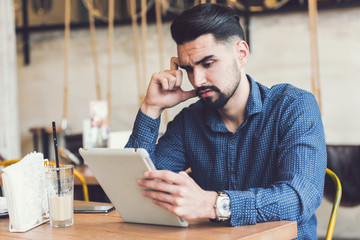 Handsome Modern Man using Tablet in Coffee Shop 