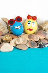 Colorful easter eggs with sunglasses surrounded by seashells on ocean beach illusion. Happy Easter holiday 