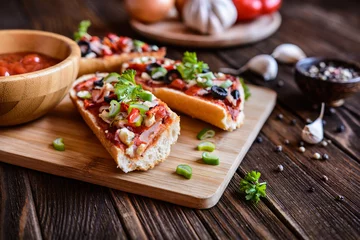 Photo sur Aluminium Pizzeria Pizza baguette avec bacon, salami, fromage et légumes