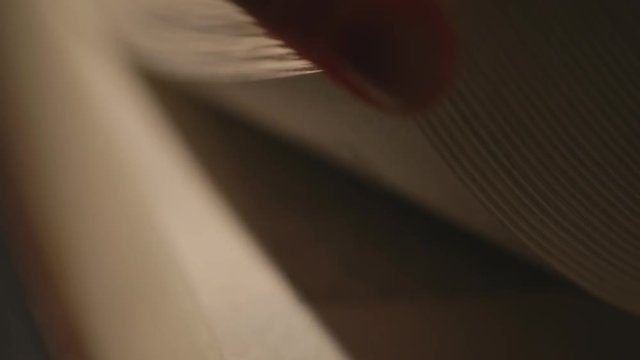 low key image of person sitting next to prayer book