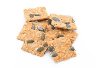 Autumn themed baked crisps with cranberries, nuts and seeds stacked on a white background.
