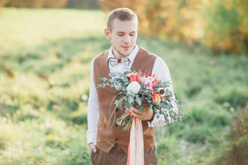The groom with the bouquet. The groom goes to meet the bride.