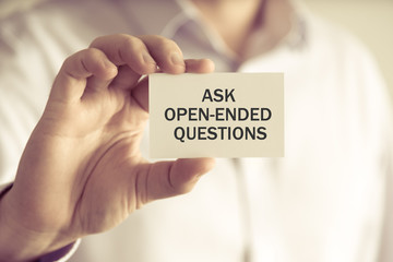 Businessman holding ASK OPEN-ENDED QUESTIONS message card - 137712368