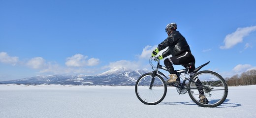 Fototapeta na wymiar 氷結の湖畔をマウンテンバイクで走る