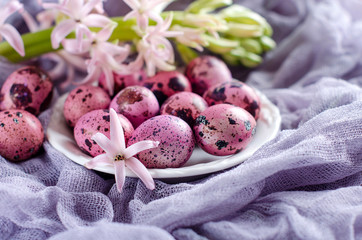 Easter eggs on a plate on a lilac runner