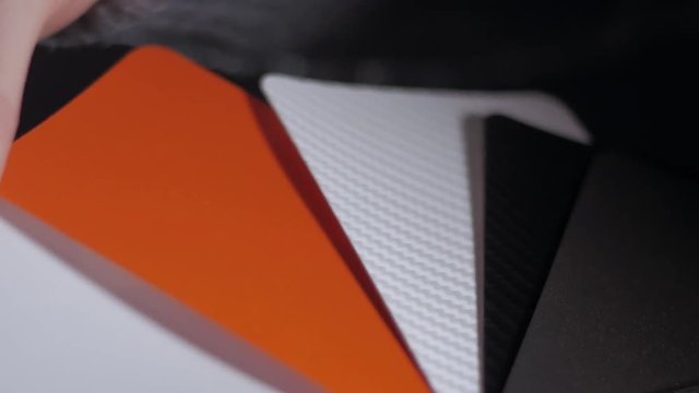 Color sampler for exterior vinyl siding isolated on black, desinger hands