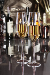 Two Glass of wine, brandy or cognac on the mirror wooden table