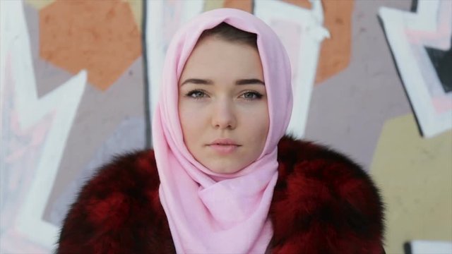 Muslim woman with her head covered with pink scarf . Full hd video