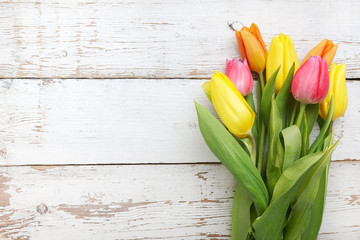 Border with pink and yellow tulips on a old white wood. Top view