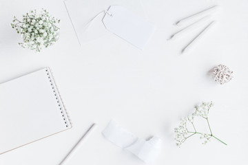 Workspace with notebook, paper blank, gypsophila flowers, pencils. Wedding concept. Flat lay, top...