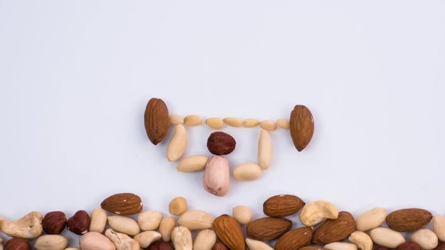 Weight Lifter made of nuts raises the bar. An athlete with a bar constructed of various nuts. Stop motion