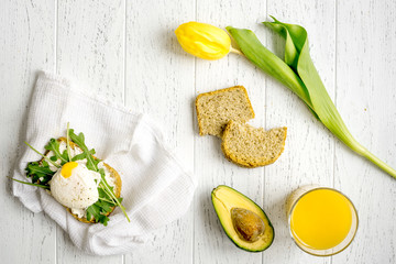 sandwich with poached eggs on wooden background top view