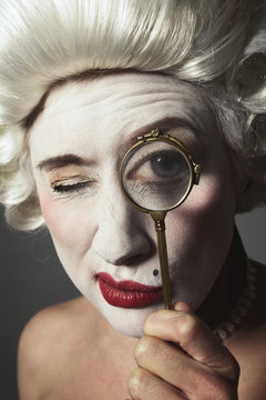 femme marquise dix-huiti&egrave;me si&egrave;cle avec perruque et teint blanc regardant &agrave; travers un lorgnon