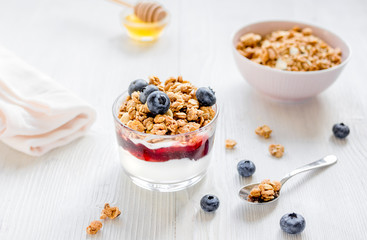 Fitness breakfast with muesli, honey and berries on white table