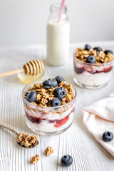 Morning granola with yogurt and berries on white kitchen background