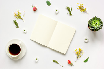 Notebook with cup of coffee on white background top view mockup