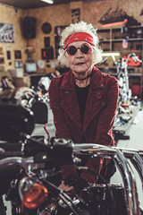 Pleased old woman bracing on bike