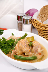 Rabbit with asparagus in red wine on a white plate decorated with parsley